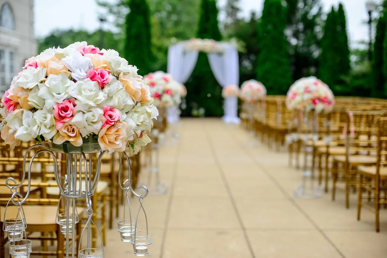 A flower-lined outdoor ceremony aisle