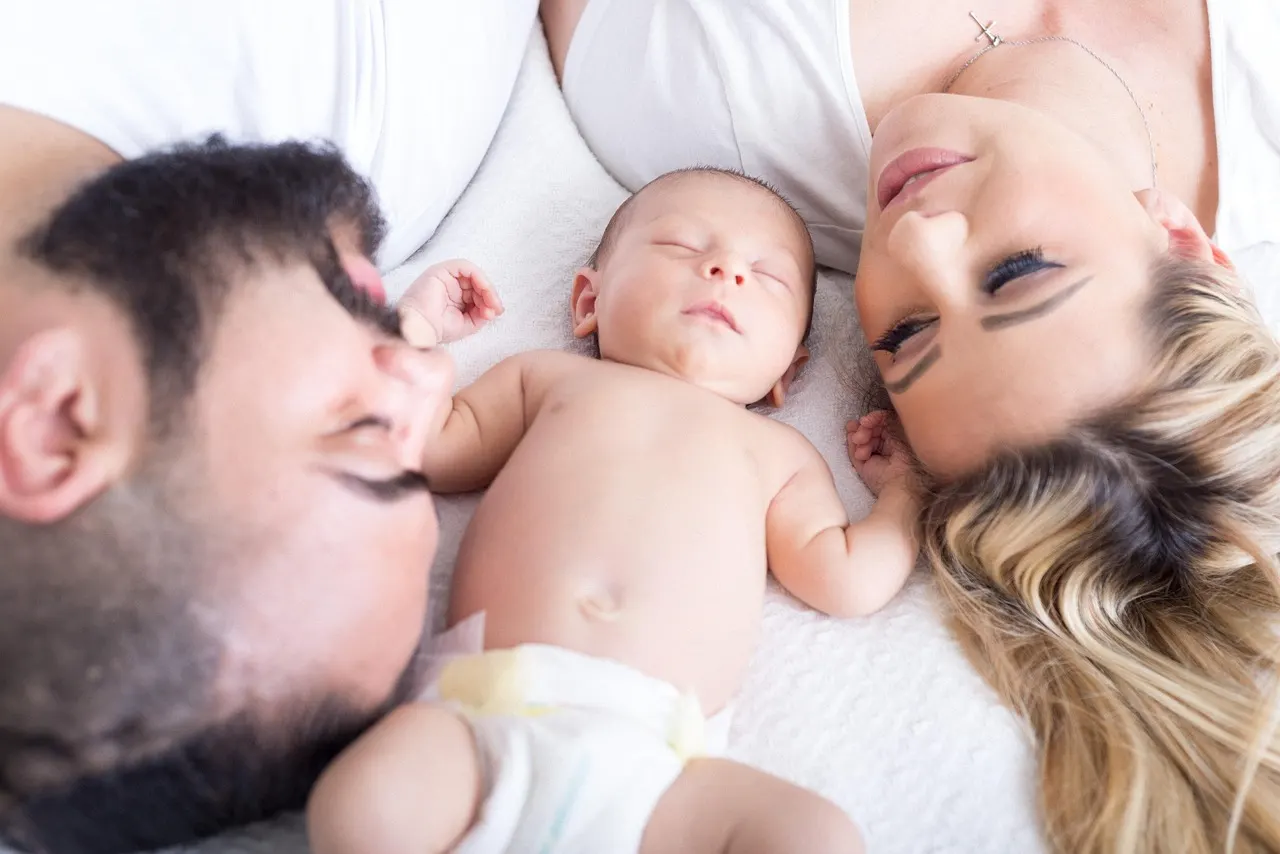 A family holding a newborn baby together